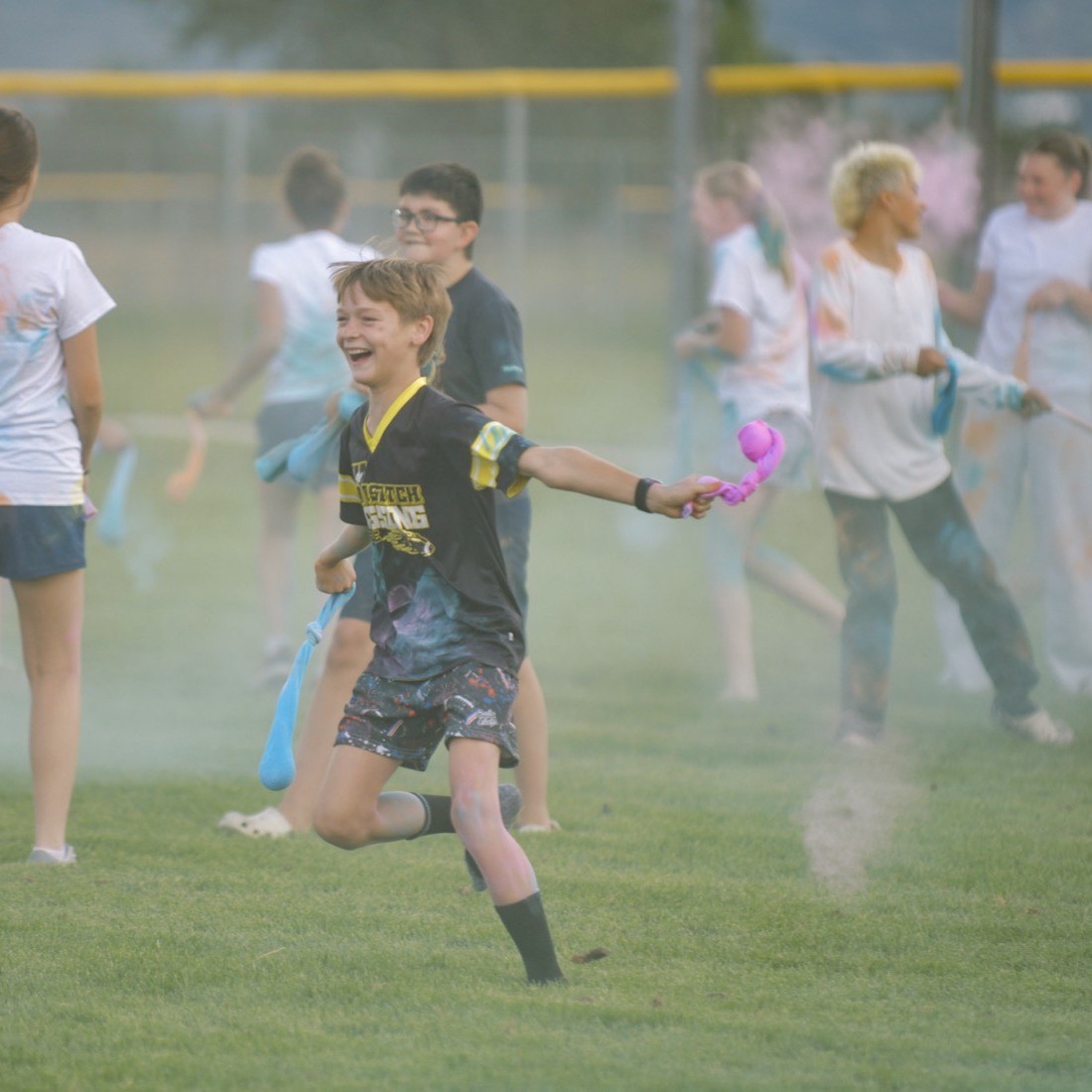 A student running through coloured powder at the MVF Students color run